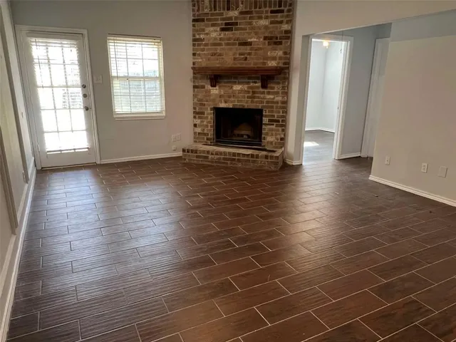 an empty room with floor to ceiling window and fireplace