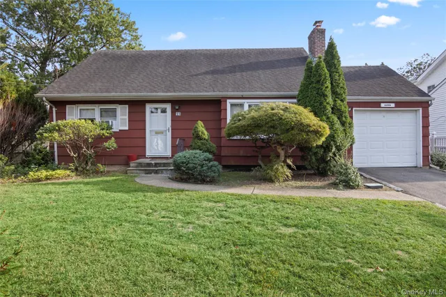 a front view of a house with a yard and potted plants