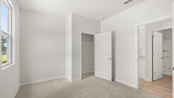an empty room with closet and wooden floor