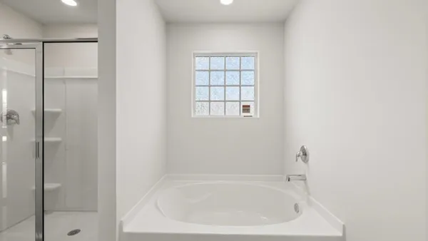 a white bath tub sitting next to a shower