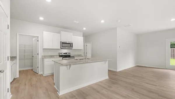 a kitchen with stainless steel appliances granite countertop a stove top oven a sink and a refrigerator