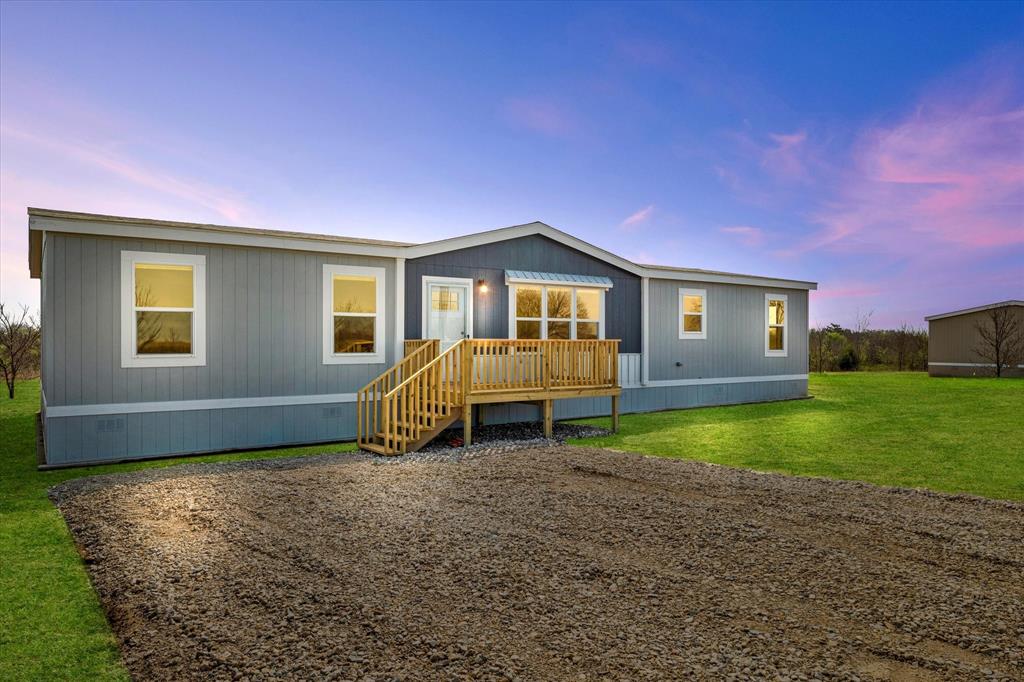 Back of house with a deck and a yard