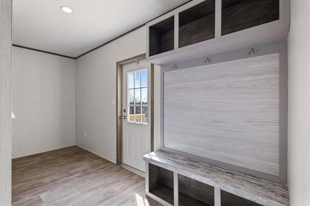 3888 Sandusky Road Whitesboro, TX 76273 - Photo 16 of 39 Mudroom with crown molding and light wood-style floors