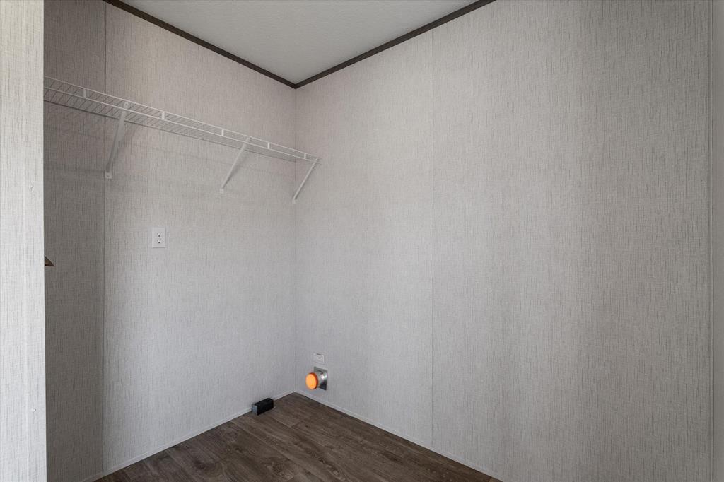 3888 Sandusky Road Whitesboro, TX 76273 - Photo 17 of 39 Laundry room featuring dark wood-style flooring and crown molding