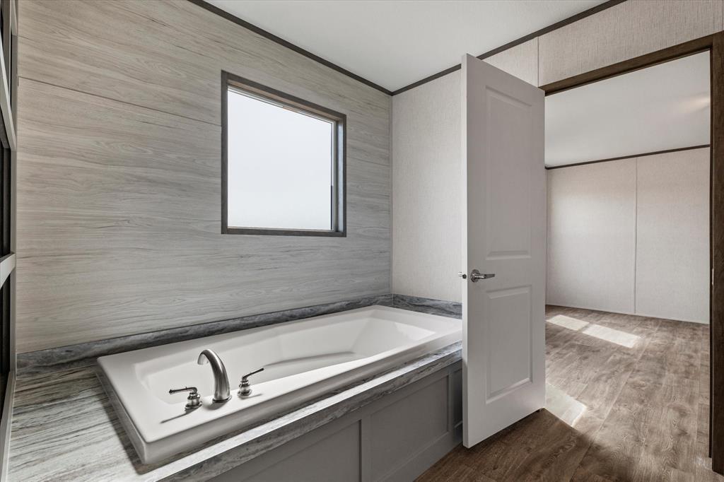 3888 Sandusky Road Whitesboro, TX 76273 - Photo 21 of 39 Full bath with crown molding, wood finished floors, and a garden tub