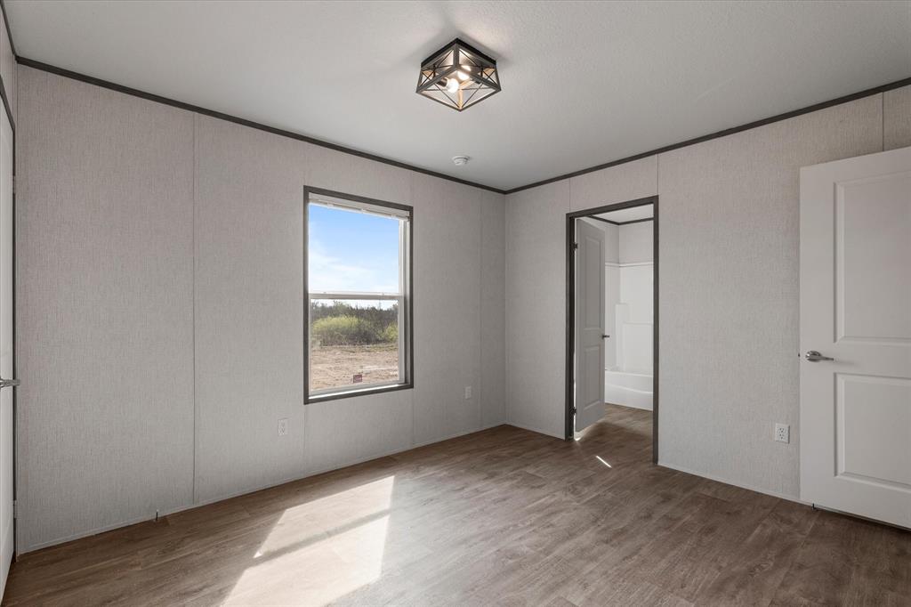 3888 Sandusky Road Whitesboro, TX 76273 - Photo 27 of 39 Unfurnished bedroom with crown molding and wood finished floors
