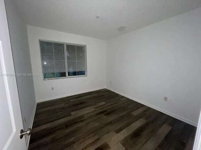 a view of a room with wooden floor and window