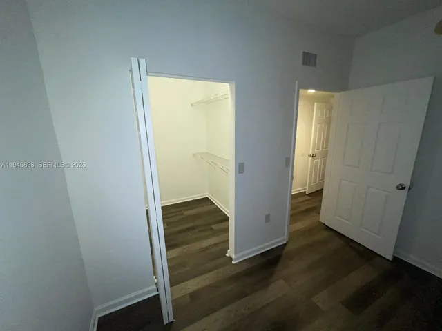 an empty room with wooden floor and closet