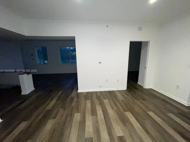a view of a room with wooden floor