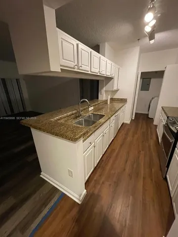 a kitchen with kitchen island granite countertop a stove and a sink
