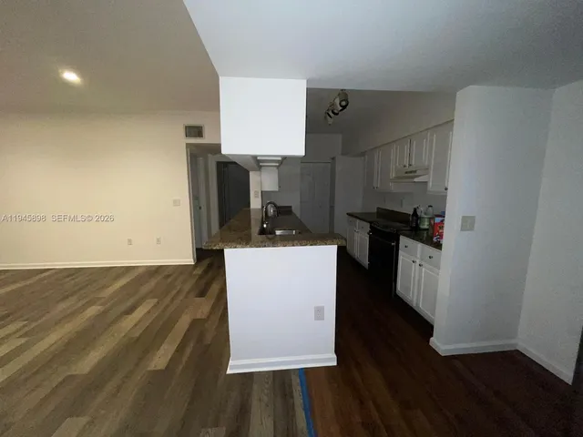 a kitchen with cabinets and wooden floor