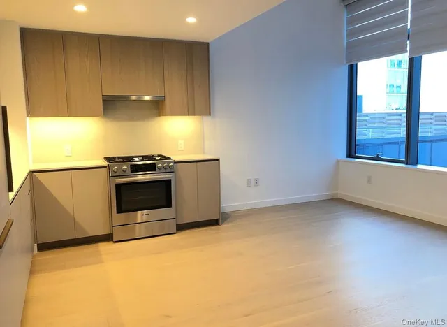 a kitchen with a stove a fridge and a window