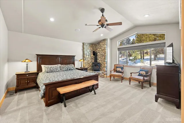 a bedroom with a bed dresser and a fireplace