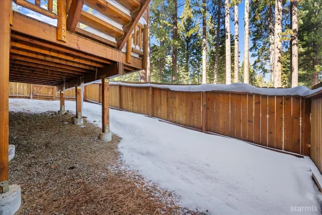 a view of a house with a yard and wooden fence