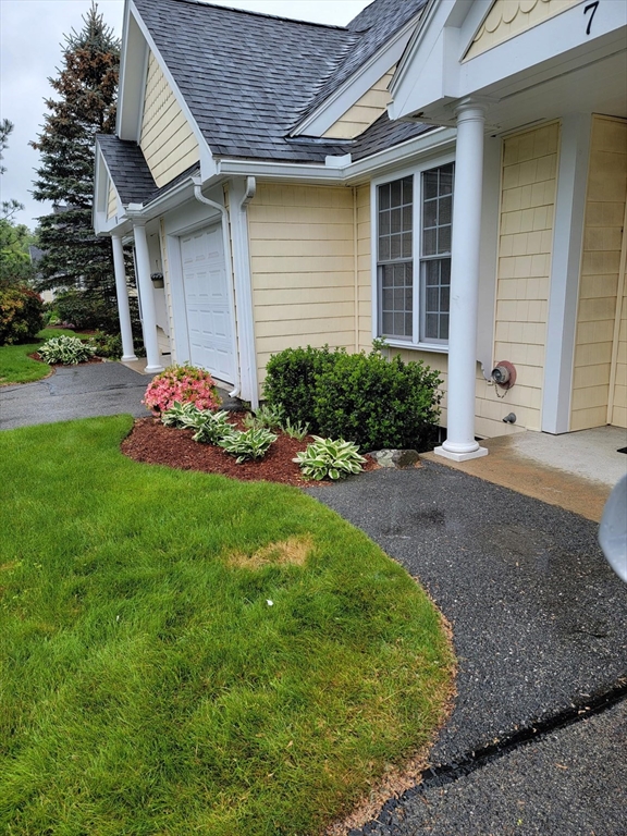 281 Rowley Bridge Road, Unit 7 Topsfield, MA 01983 - Photo 20 of 32 a front view of a house with a garden