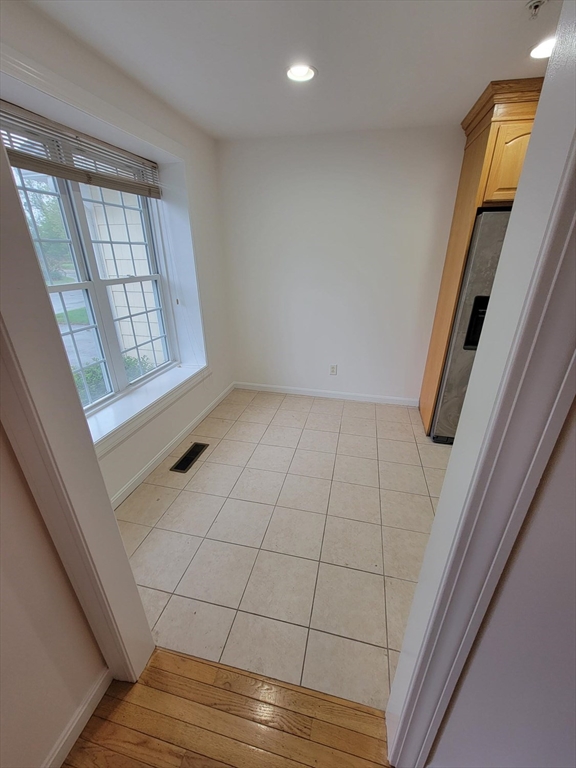 281 Rowley Bridge Road, Unit 7 Topsfield, MA 01983 - Photo 3 of 32 a view of an empty room with wooden floor and a window