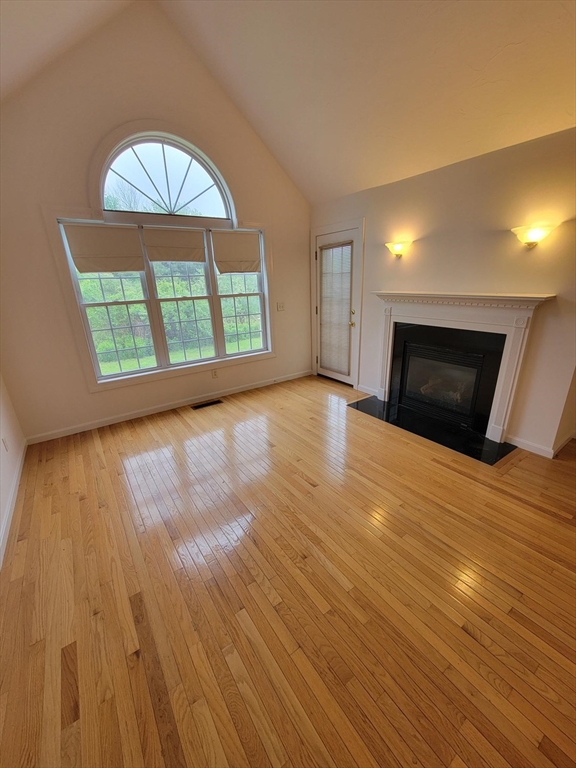 281 Rowley Bridge Road, Unit 7 Topsfield, MA 01983 - Photo 6 of 32 an empty room with wooden floor windows and a fireplace