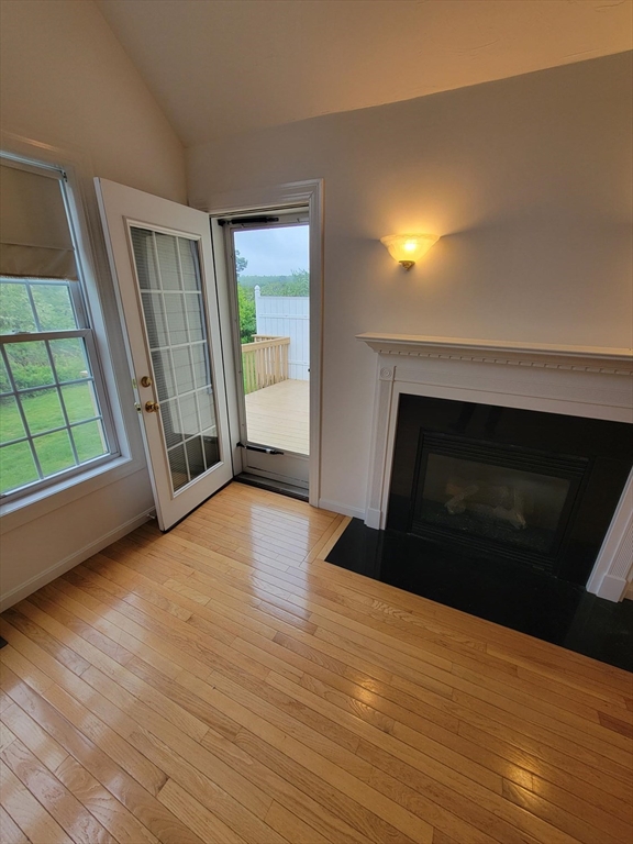 281 Rowley Bridge Road, Unit 7 Topsfield, MA 01983 - Photo 7 of 32 a view of empty room with wooden floor and fireplace