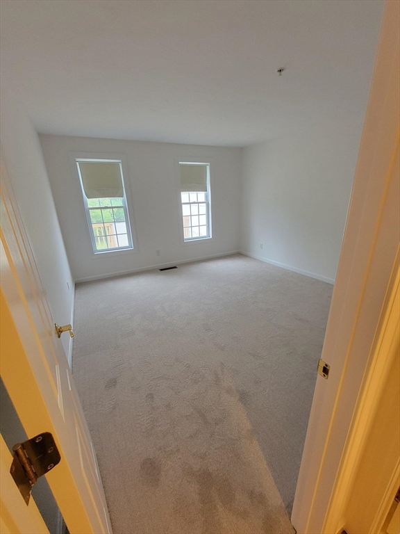 281 Rowley Bridge Road, Unit 7 Topsfield, MA 01983 - Photo 9 of 32 a view of an empty room and a windows