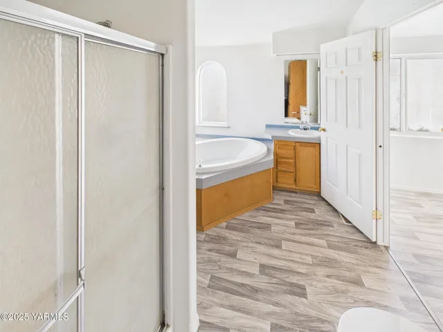 a bathroom with a tub sink and mirror