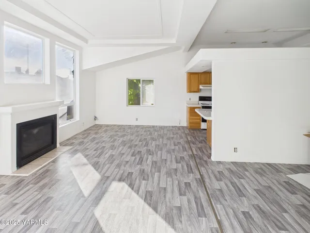 a view of empty room with wooden floor and fireplace