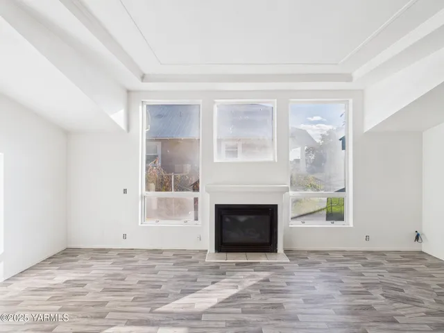 a view of empty room with a fireplace and window