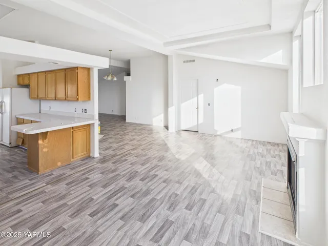 a view of a kitchen with wooden floor and electronic appliances