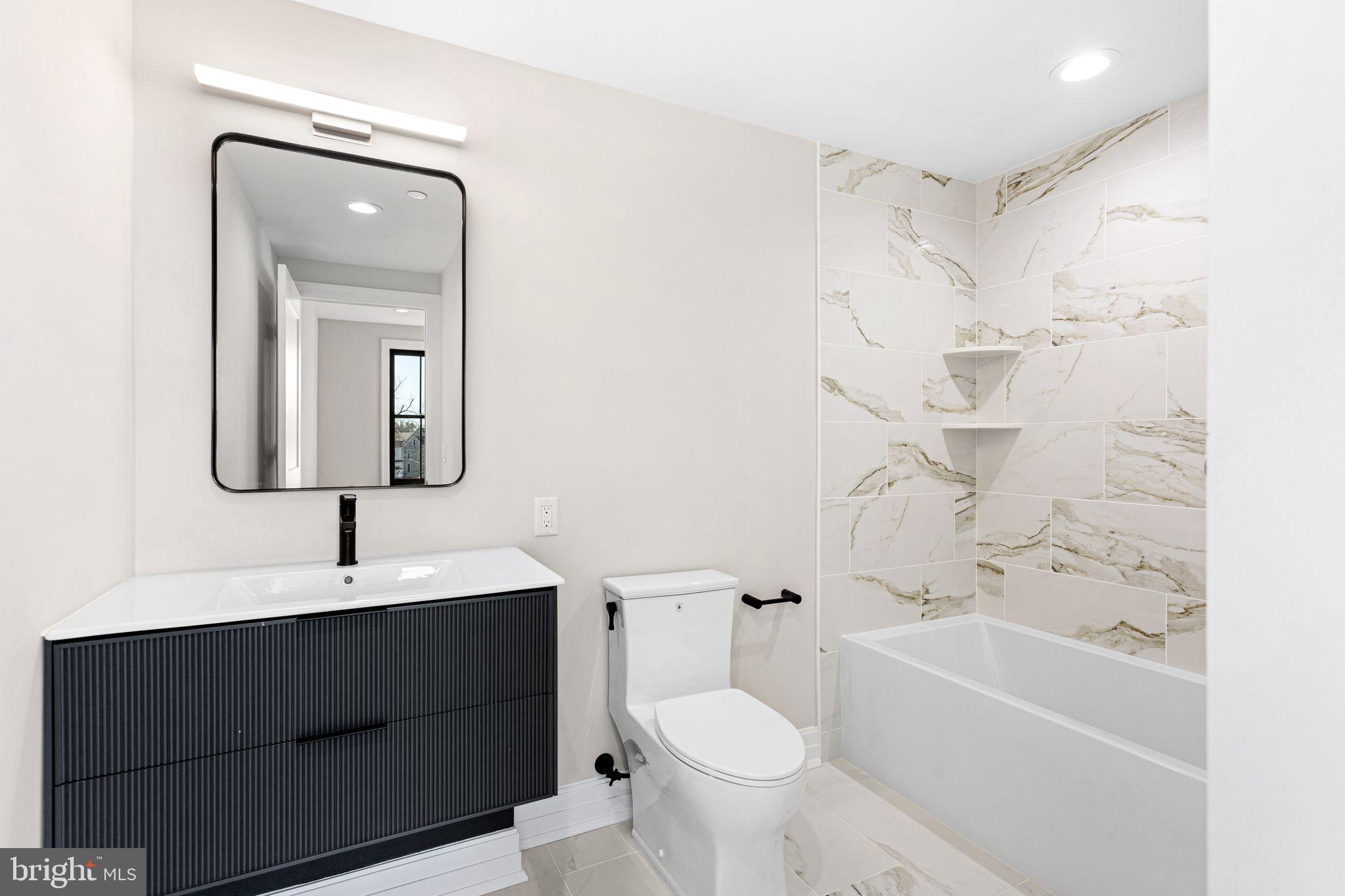 151 Kings Highway East, Unit A Haddonfield, NJ 08033 - Photo 18 of 24 a bathroom with a sink toilet a mirror and shower