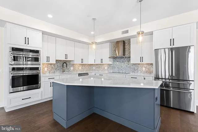 a kitchen with kitchen island a sink stainless steel appliances and cabinets