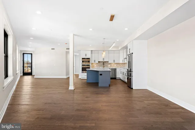 a view of kitchen with kitchen island wooden cabinets and refrigerator