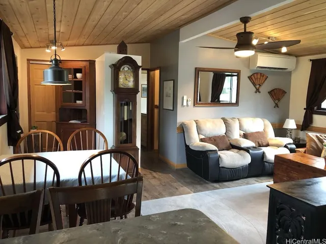a living room with furniture a flat screen tv and kitchen view