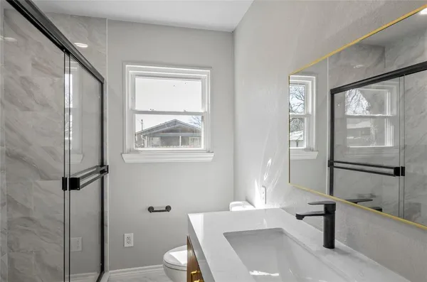 a bathroom with a sink a toilet and a large window