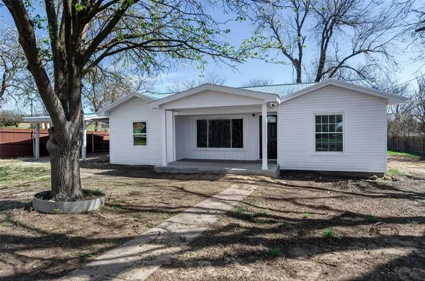 a view of a house with a yard tree and wooden fence