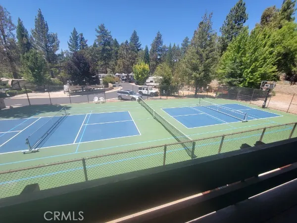 a view of a tennis ground with trees in the background