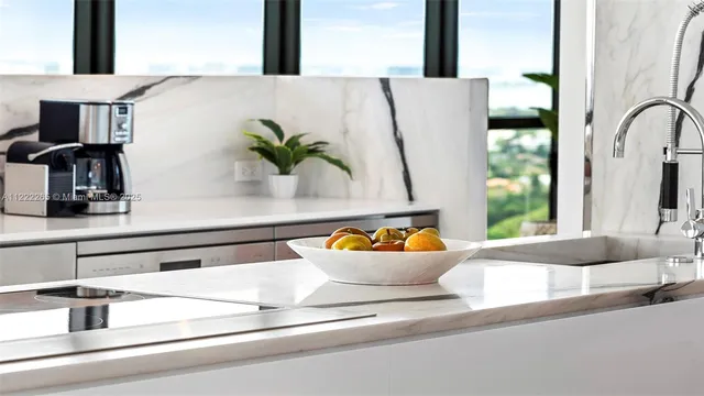 a open kitchen with stainless steel appliances granite countertop a stove a sink and a dining table