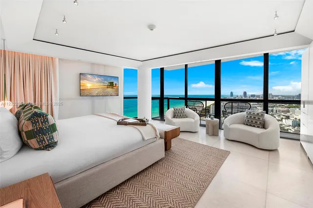 a bedroom with furniture and a large window