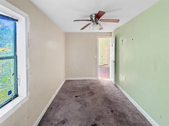 a view of a livingroom with a ceiling fan and window