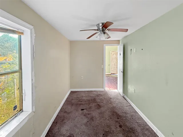 a view of room with a ceiling fan and window