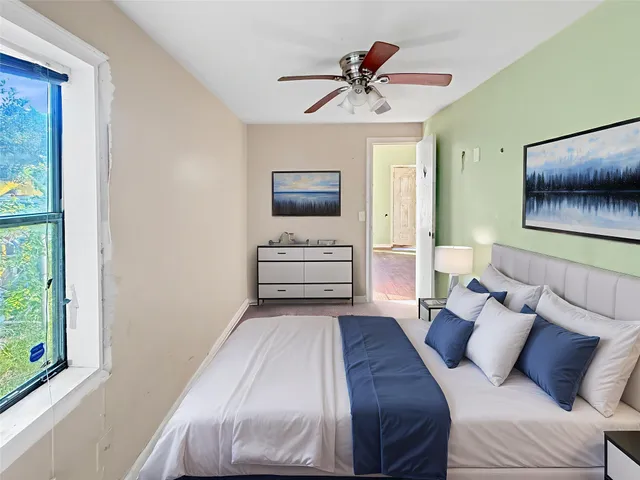 a bedroom with a large bed and a window