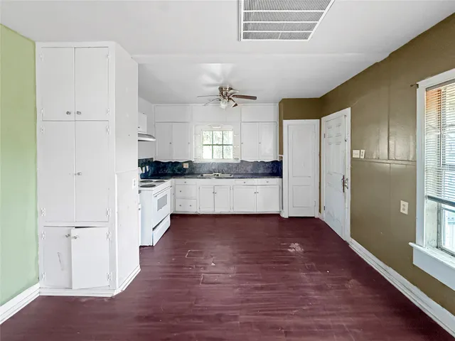 a large kitchen with cabinets wooden floor and stainless steel appliances