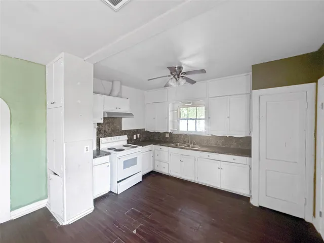 a kitchen with white cabinets and white appliances