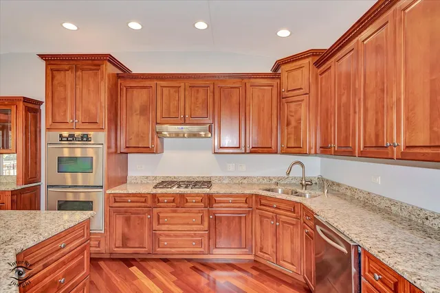 a kitchen with stainless steel appliances granite countertop a sink stove and cabinets