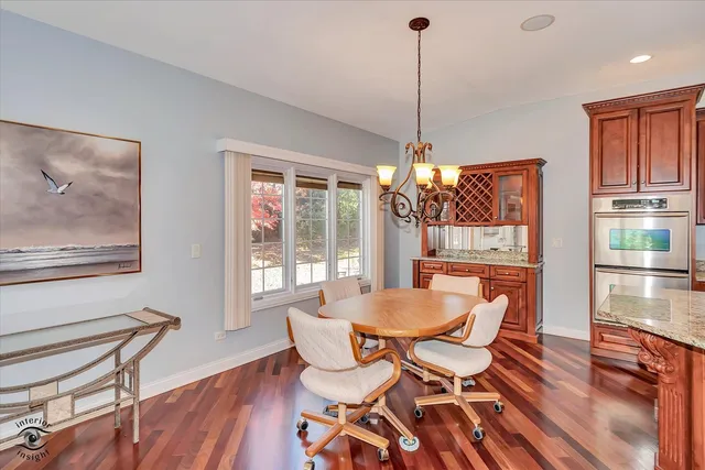 a dining room with furniture a chandelier and wooden floor