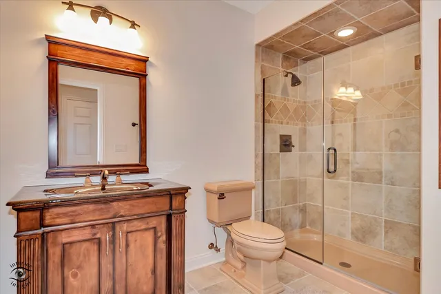 a bathroom with a granite countertop sink a toilet and shower