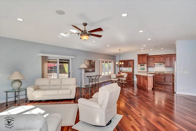 a living room with furniture kitchen view and a wooden floor