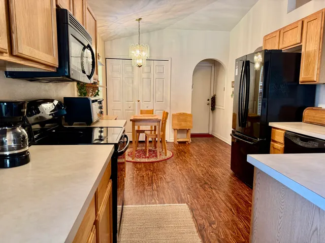 a kitchen with stainless steel appliances granite countertop a refrigerator a stove and a sink