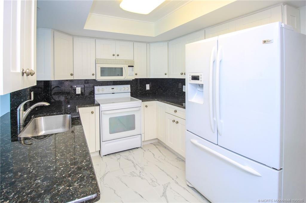 8750 South Ocean Drive, Unit 1635 Jensen Beach, FL 34957 - Photo 6 of 36 a kitchen with stainless steel appliances a stove a microwave and a refrigerator