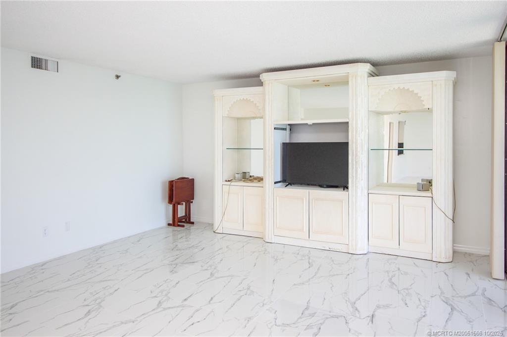 8750 South Ocean Drive, Unit 1635 Jensen Beach, FL 34957 - Photo 9 of 36 a living room with furniture and a flat screen tv