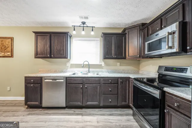 a kitchen with stainless steel appliances granite countertop a sink and stove top oven