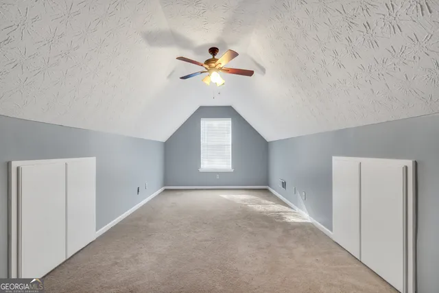 a view of a room with a ceiling fan and a window